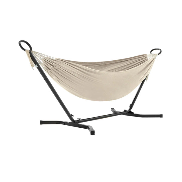 Beige cotton hammock on black steel stand on white background
